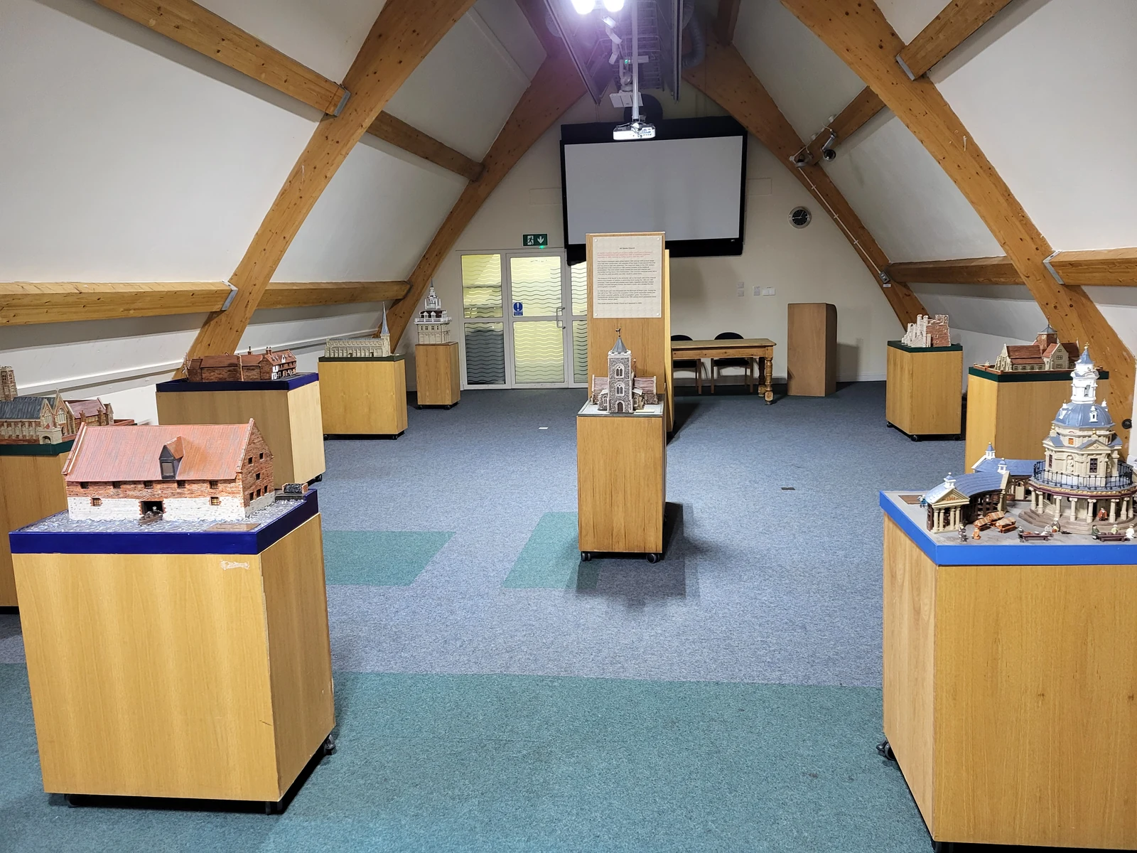 Building models displayed beneath the warehouse's timber roof